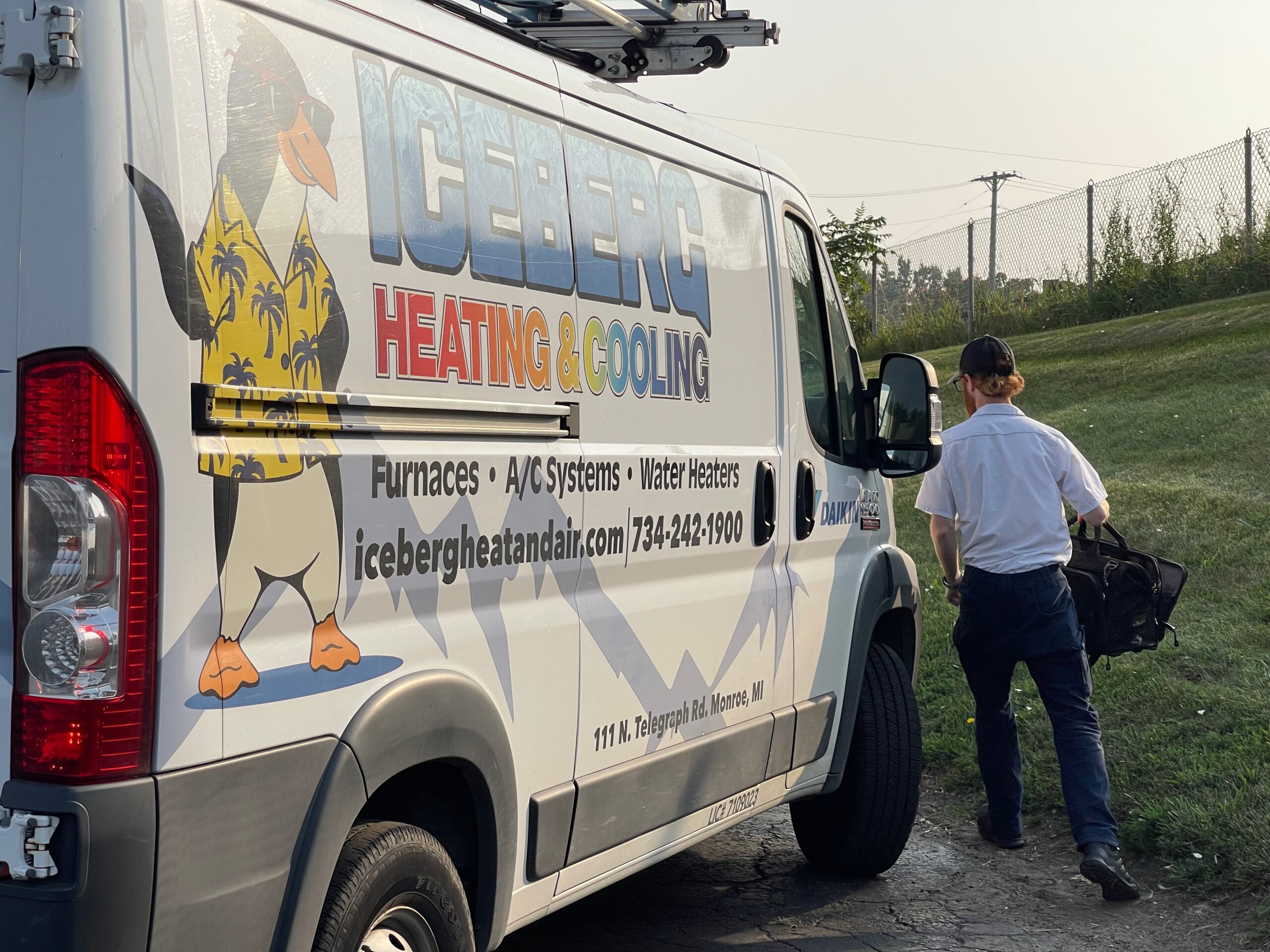 Iceberg Heating & Cooling technician next to a company truck