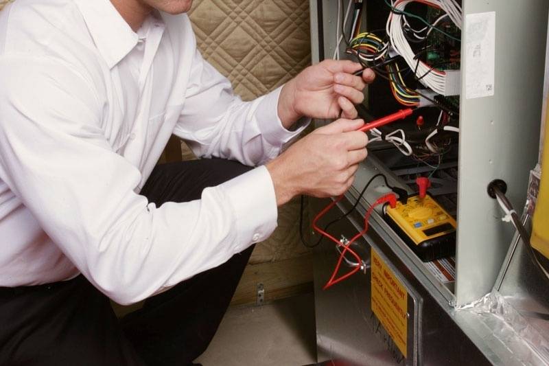 Technician fixing a residential furnace