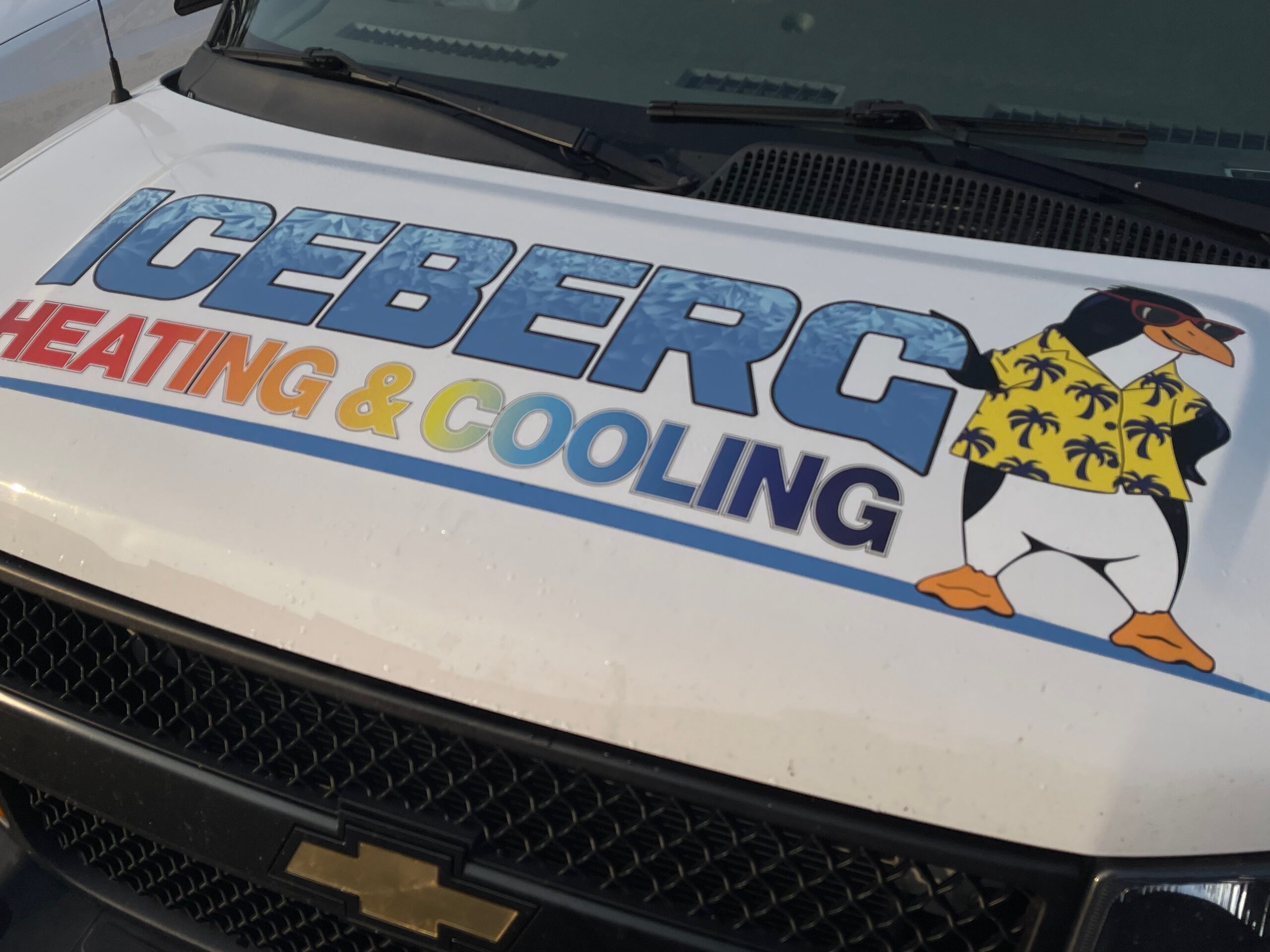 The hood of an Iceberg Heating  & Cooling work truck with the company logo